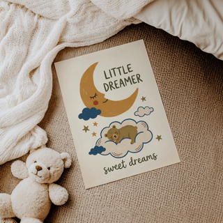 Print lying on carpet with a teddy bear nearby showing a sleeping bear on a cloud illustration