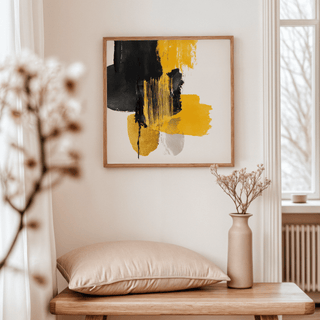 Abstract Poster Art framed print with black and yellow brushstrokes above a beige cushion on a wooden bench