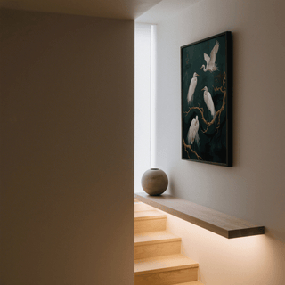 Elegant Bird Art Print of white egret birds on dark green background hung by stairs with a round vase nearby