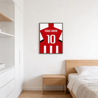 Framed Football Shirt Poster in Red and White Stripes with White Number above a bedside table in a bedroom