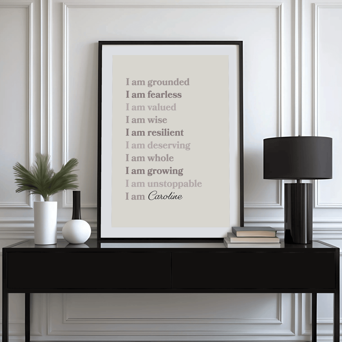 Custom Quote Poster leaning on a black sideboard with a black lamp and plants nearby