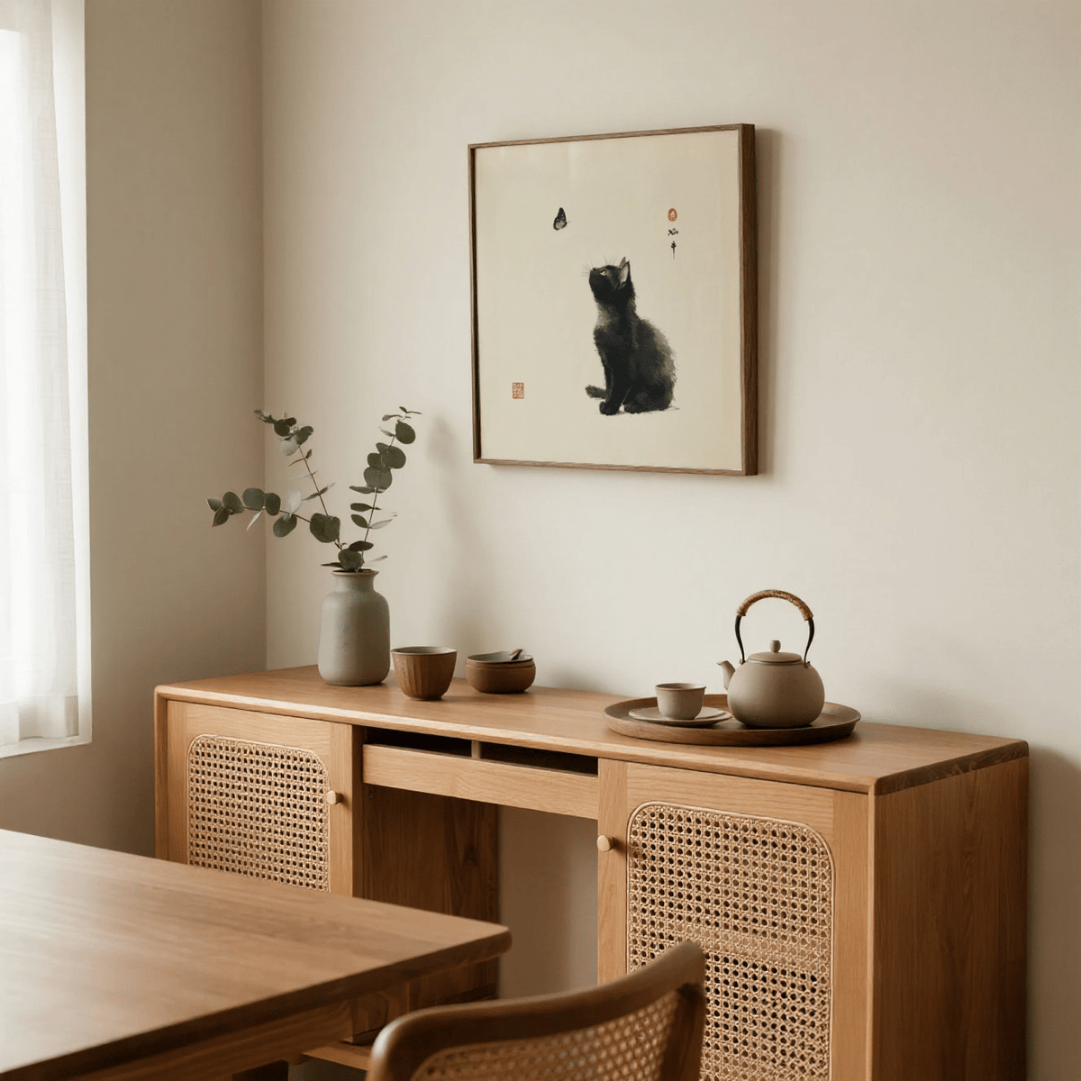 Butterfly Cat Poster print leaning on a beige wall with natural wooden furniture and ceramic teapot