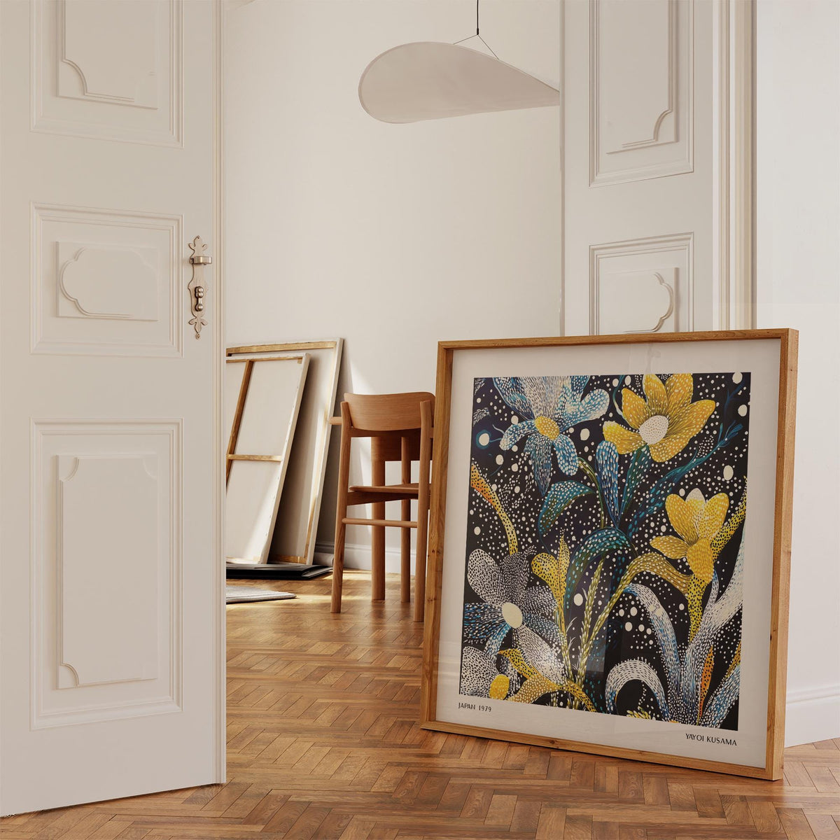 Dark Floral Wall Art print leaning on a wooden floor with a chair in a room