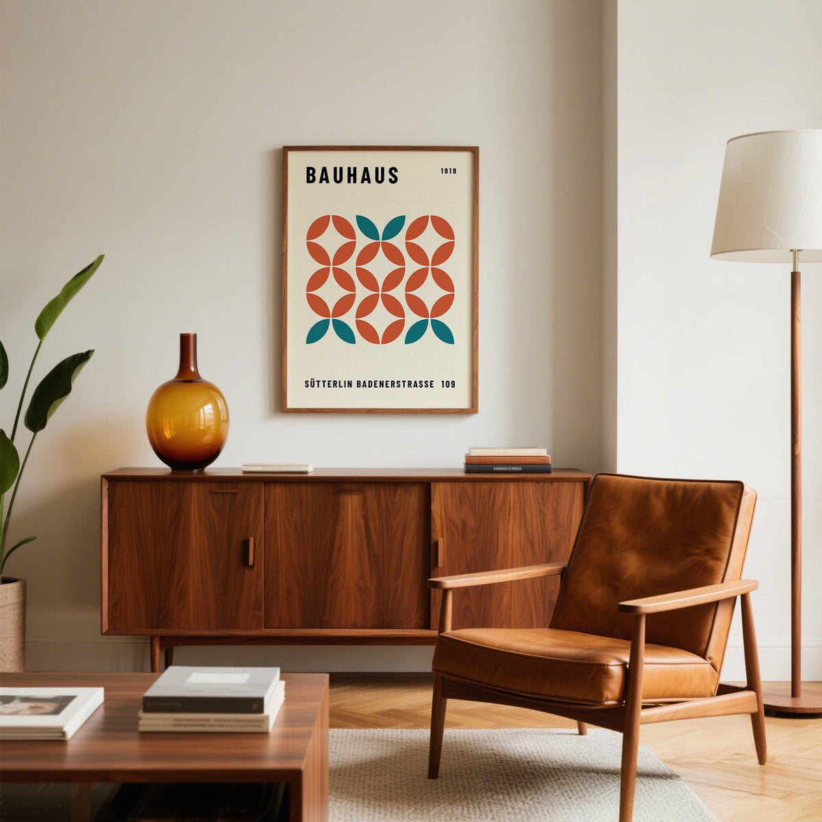 Modern Geometric wall art with teal and orange shapes above a wooden sideboard and next to a leather chair