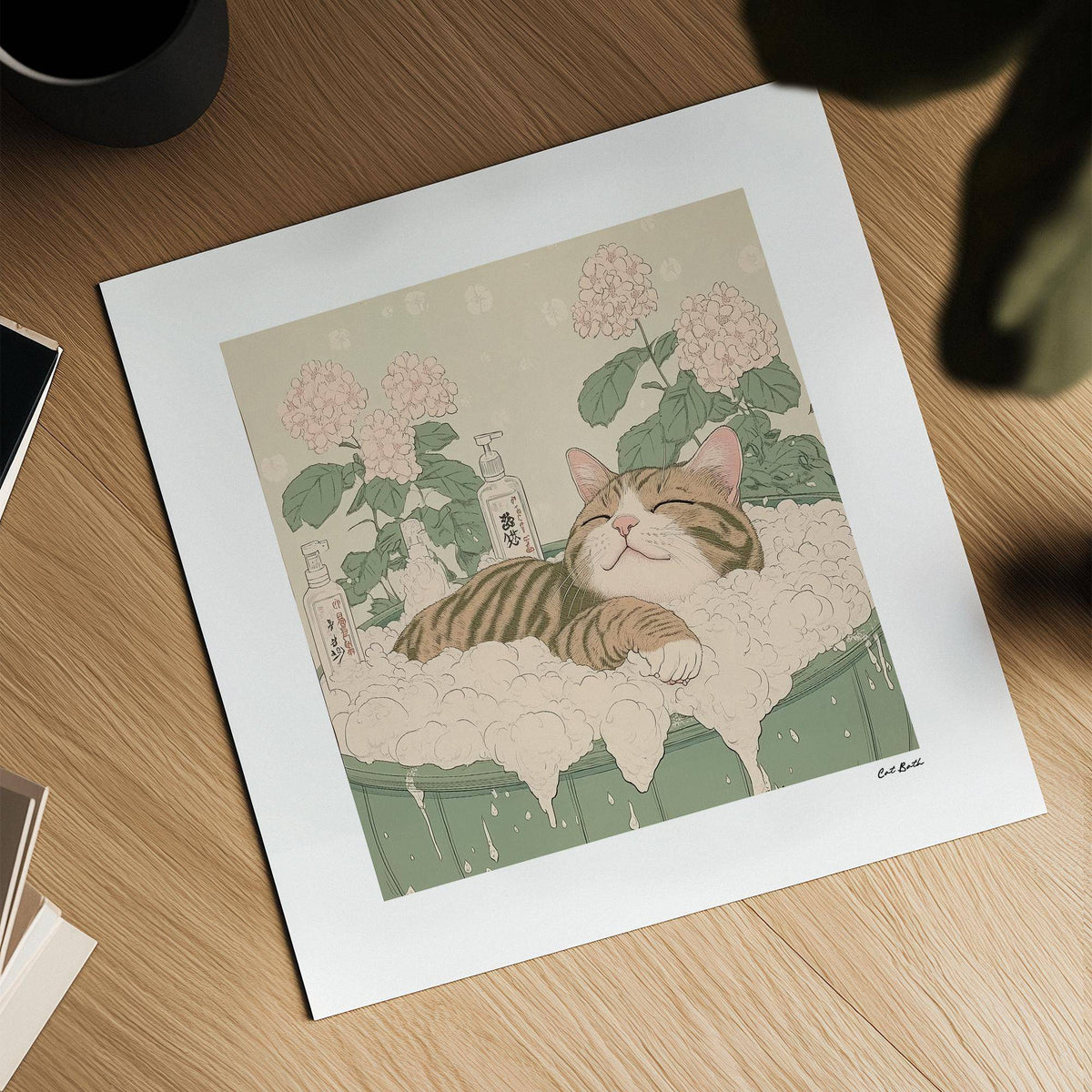 Close-up of Japanese Posters with tabby cat in bubble bath and pink flowers on a wooden surface