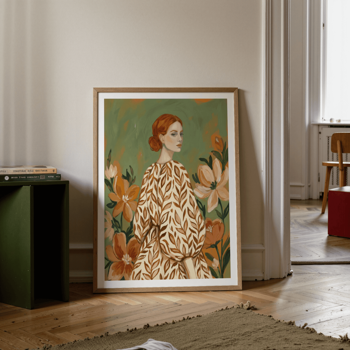 Floral Girl Illustration print leaning on floor by a stack of books with green and orange tones in a modern room