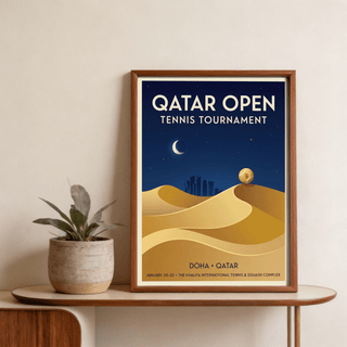 Framed Qatar Open Tennis Print with a tennis ball on sand dunes next to a plant on a table