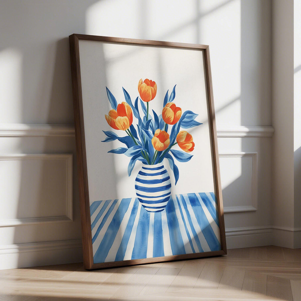 Print leaning on floor of tulip wall art with orange flowers and blue striped vase in bright room