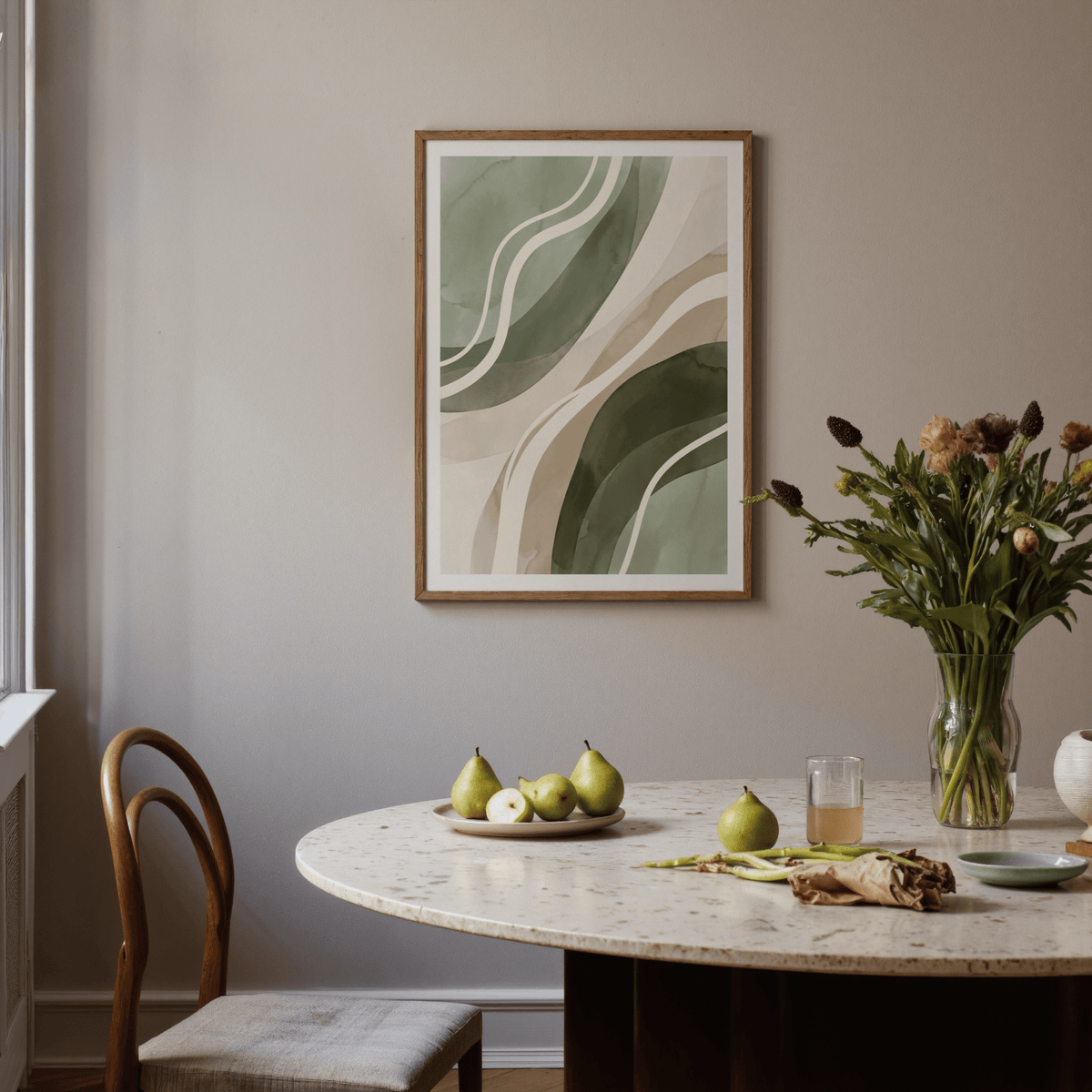 Green Abstract Print on a wall above a dining table with fruit and flowers in a vase