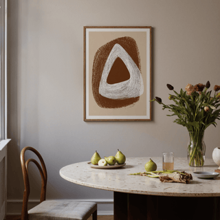 Boho Geometric Art Print with brown and white triangles above a dining table with a plate of pears