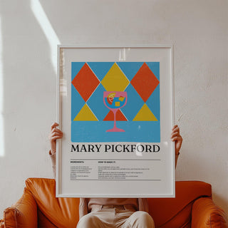 Framed print of Mary Pickford cocktail illustration with geometric shapes held above a brown sofa