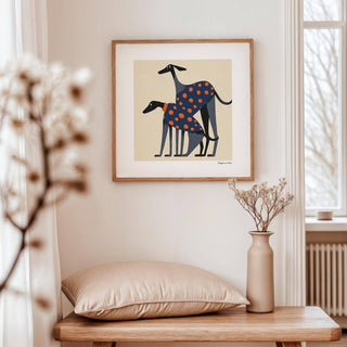 Poster of a Dog framed print two greyhounds with orange polka dot coats above a wooden table