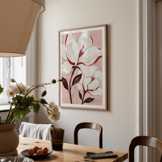 Flower print of white magnolia flowers with red details in a dining room beside a vase of flowers