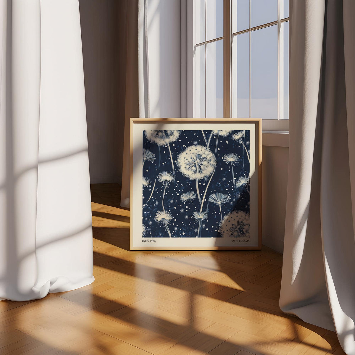 Navy and White wall art leaning on floor showing dandelion seeds in a sunlit room with curtains