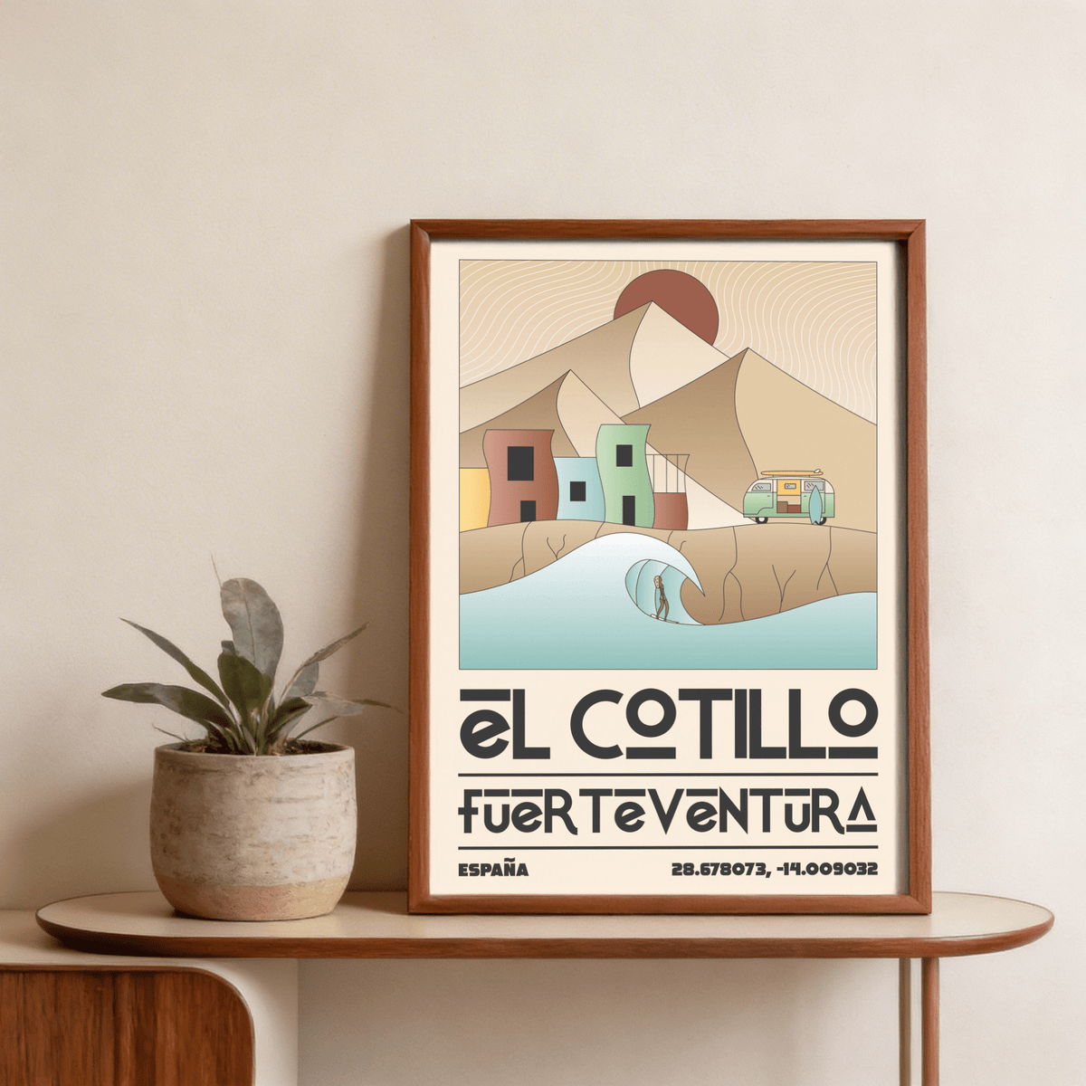 Framed El Cotillo Surfing Poster with muted colours beside a potted plant on a wooden shelf