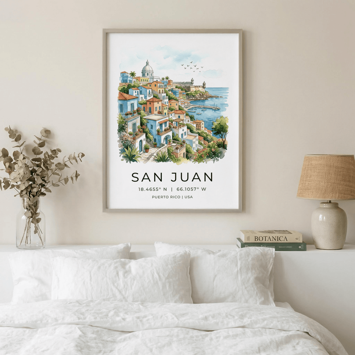 San Juan Art Print watercolour illustration of the coastline framed above a white bed with books and lamp