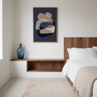Abstract Art Shapes framed print with beige and navy shapes above a wooden shelf with a blue vase in a bedroom