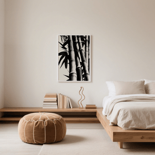 Bamboo Black And White Print on bedroom wall above a beige pouffe with stacks of books