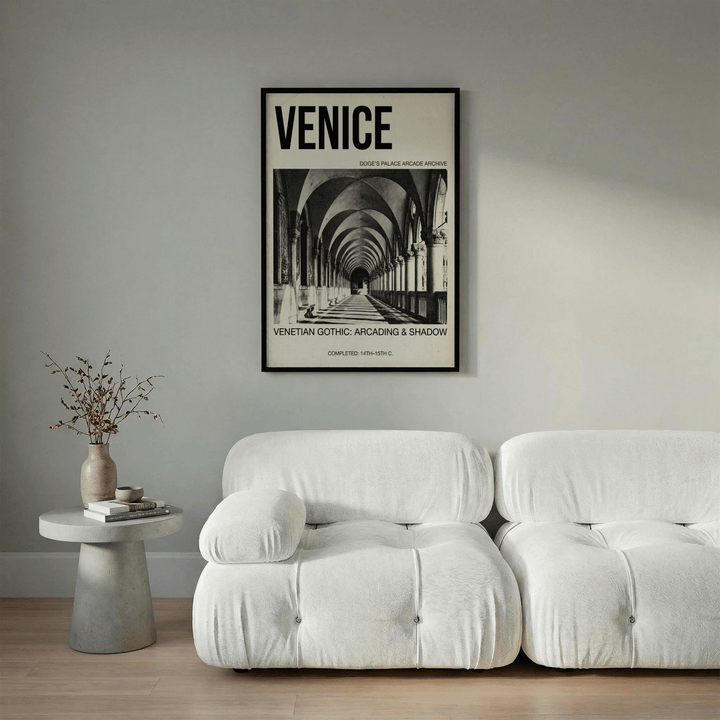 Framed Venetian Gothic wall art with black and white arcade photograph above a white sofa
