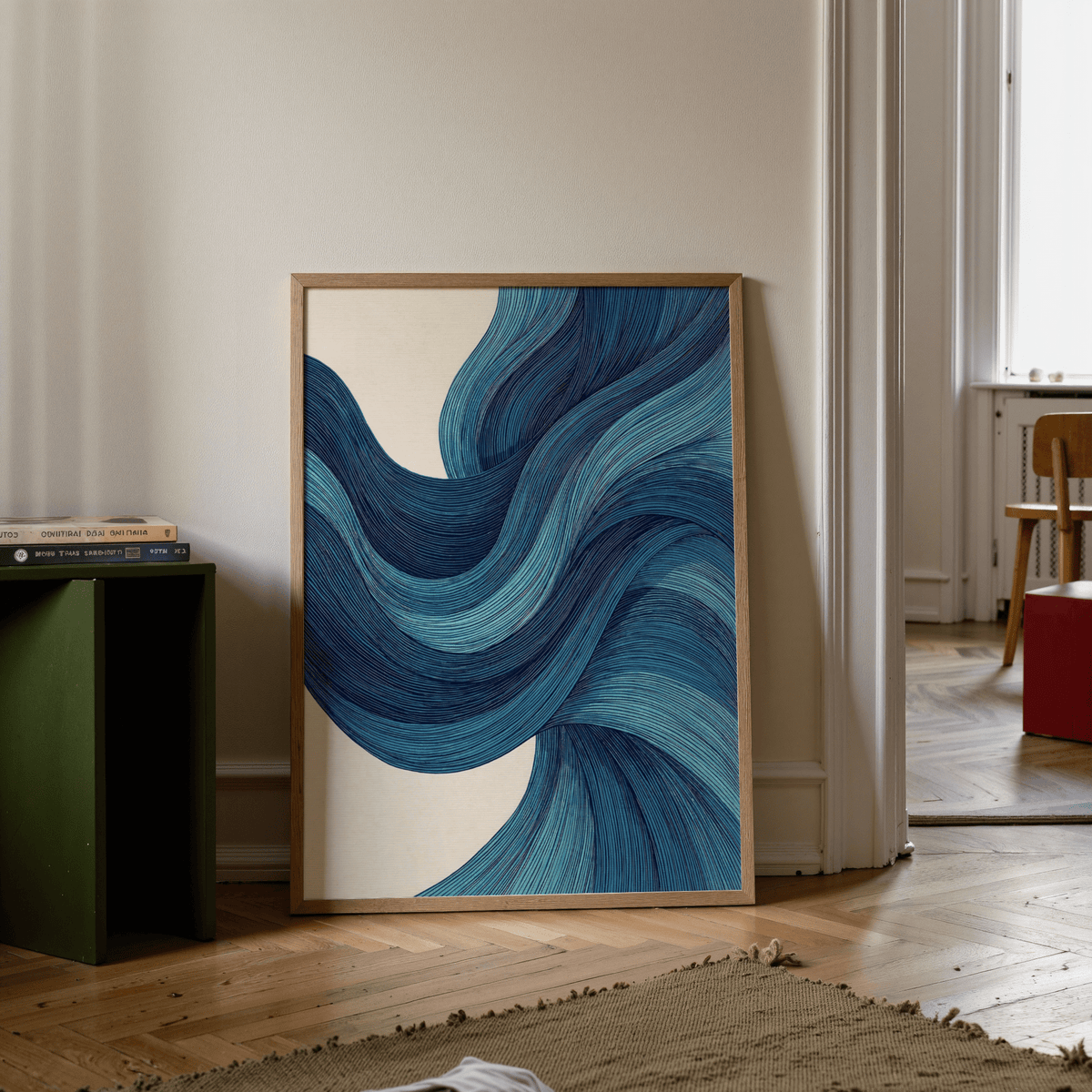 Abstract Wave Art print leaning on the floor with blue wave lines and a wooden frame near a green side table