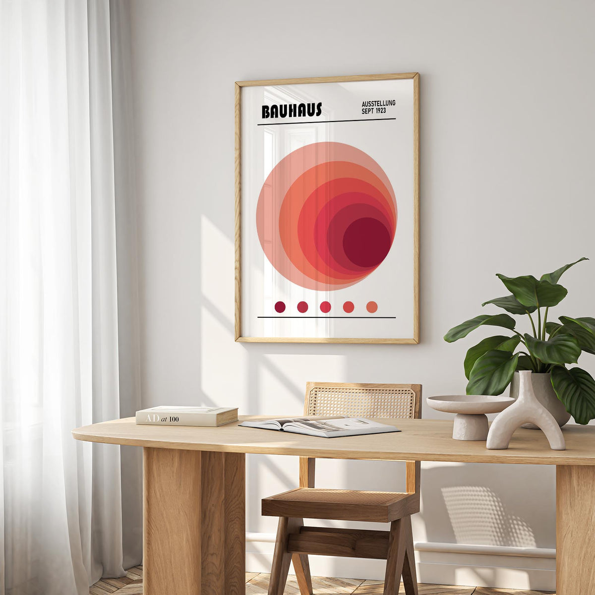 Wall Art Office framed print of concentric circles in shades of red above a wooden desk with plant