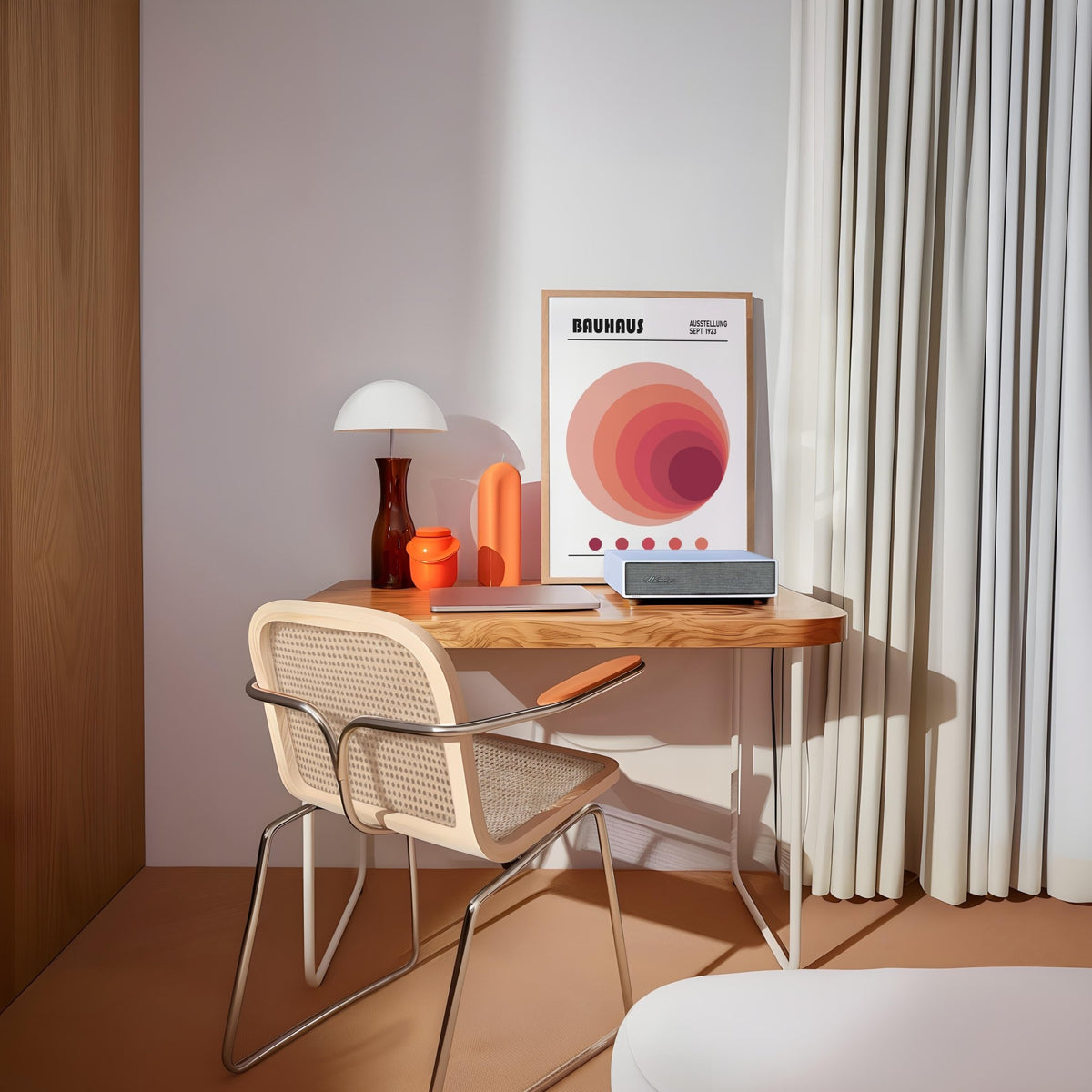 Wall Art Office leaning print with concentric circles in shades of red and orange on a wooden desk beside a lamp
