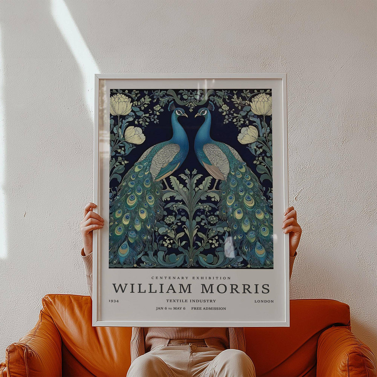 Framed print of Large Peacock Wall Art with blue and green peacocks held in front of a rust leather sofa