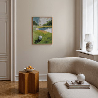 Golf Landscape wall art of a golf ball on a green fairway in a beige sitting room with a wooden side table