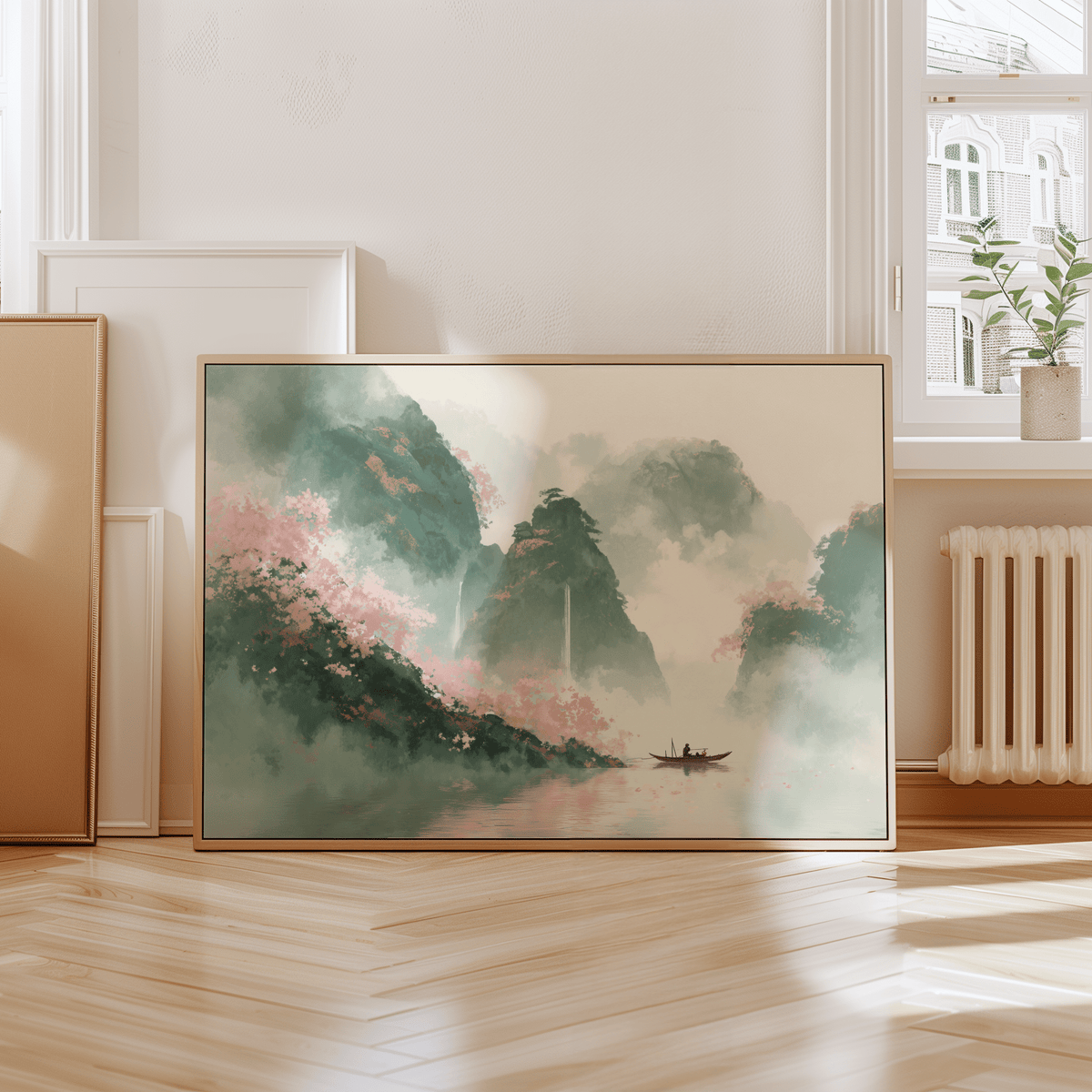 Mountain landscape art print of misty green and pink mountains leaning on the floor beside a vase