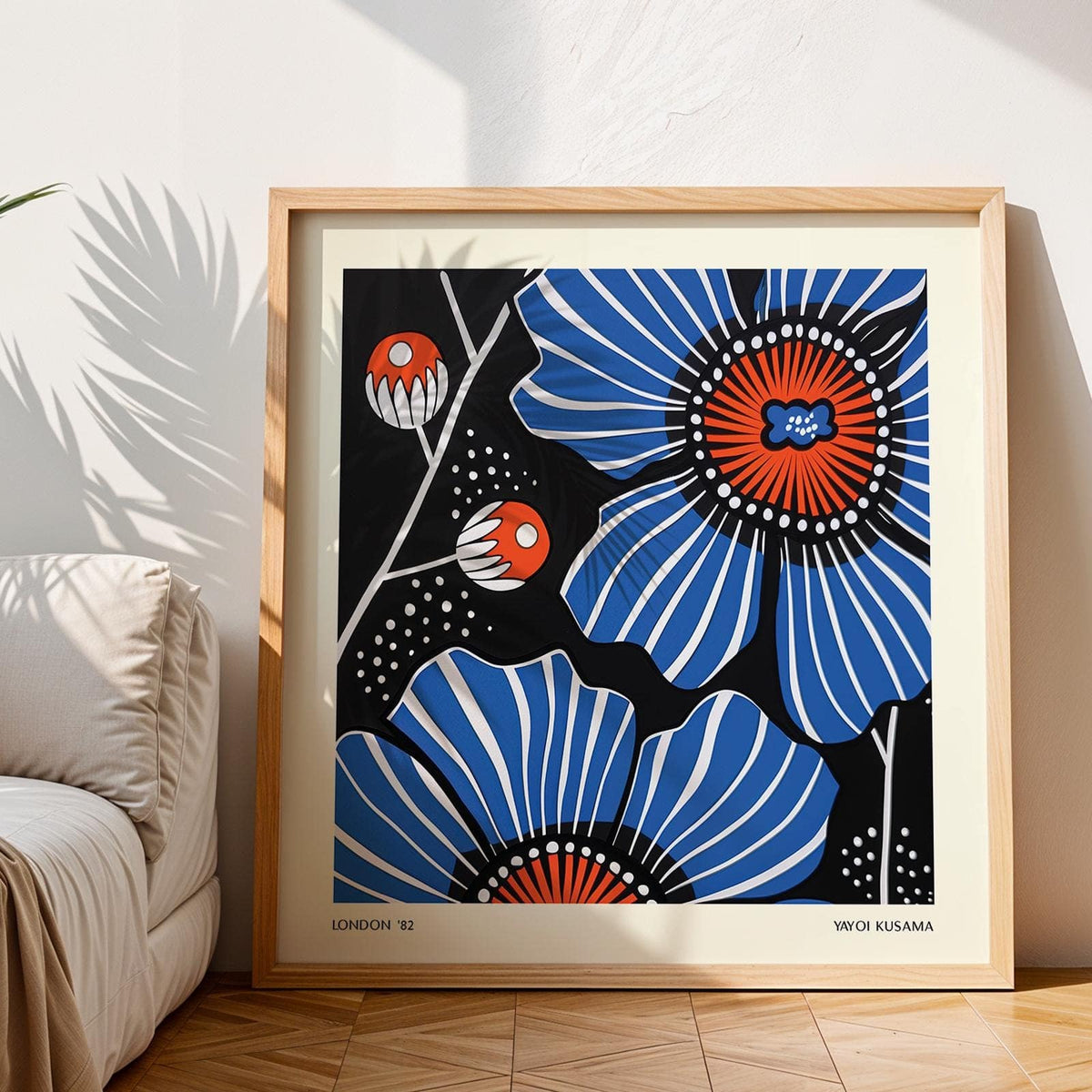 Flowers prints leaning on the floor with blue poppies and orange centres with sunlight and sofa nearby