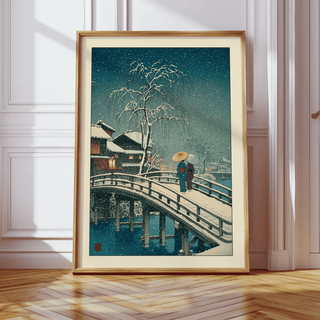 Framed close-up of Hasui Kawase Snow Print showing a snowy bridge with two people and a large tree