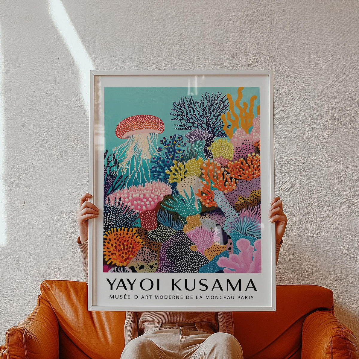 Framed coral reef art with colourful corals and a jellyfish held above an orange chair