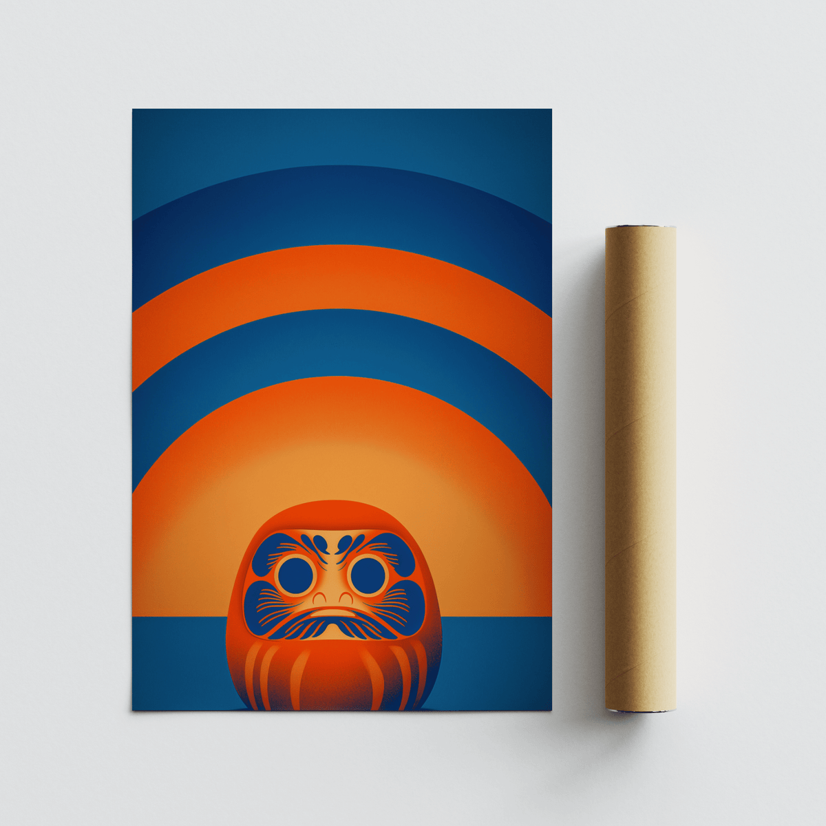 Daruma Doll wall art print alongside a brown packaging tube on a white surface