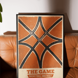 Framed Basketball Abstract Print with orange and black vintage design on a brown leather sofa