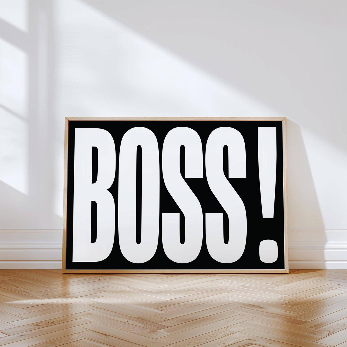 Gift for Boss print leaning on a wooden floor with sunlight and shadows on a pale grey wall