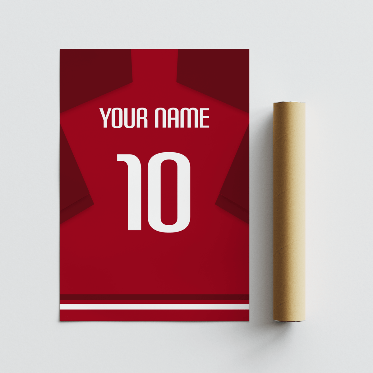 Football Shirt Poster in Red with Dark Red Sleeves next to a brown packaging tube on a pale surface