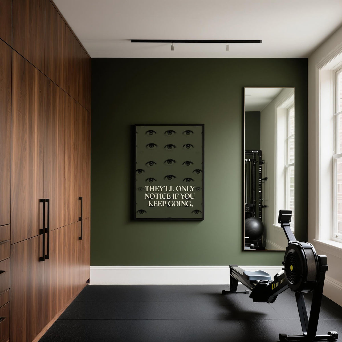 Gym Artwork on dark green wall with minimalist eyes and text above a rowing machine