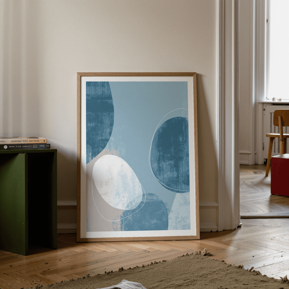Contemporary Pattern Poster leaning on a wooden floor near a green side table with books