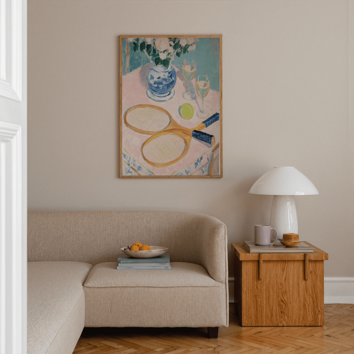 Print on a wall in a living room of wooden tennis rackets and ball with blue and pink tones