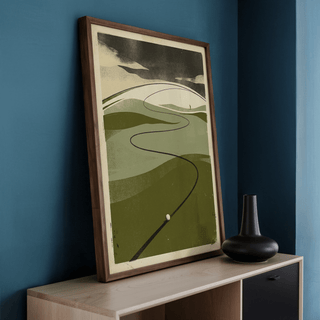 Print leaning on a shelf of minimalist retro golf course with green fairway and dark shadow and black vase nearby