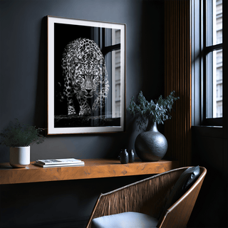 Black leopard wall art in black and white above a wooden shelf with plants in a room with large windows