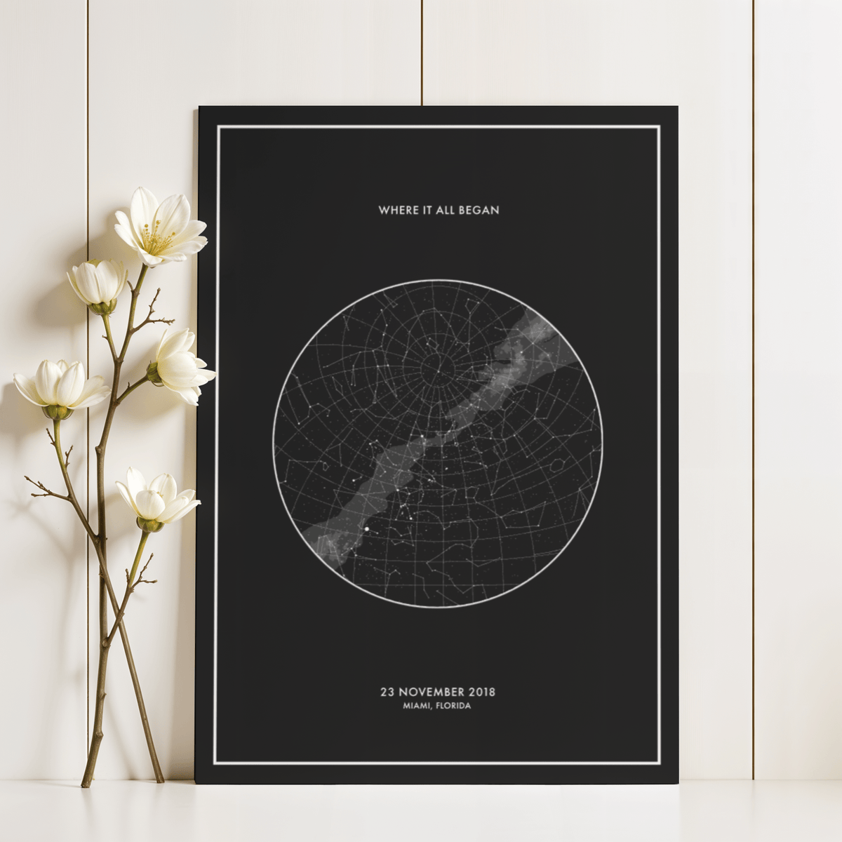 Custom Star Map print leaning on a white shelf with white flowers beside it