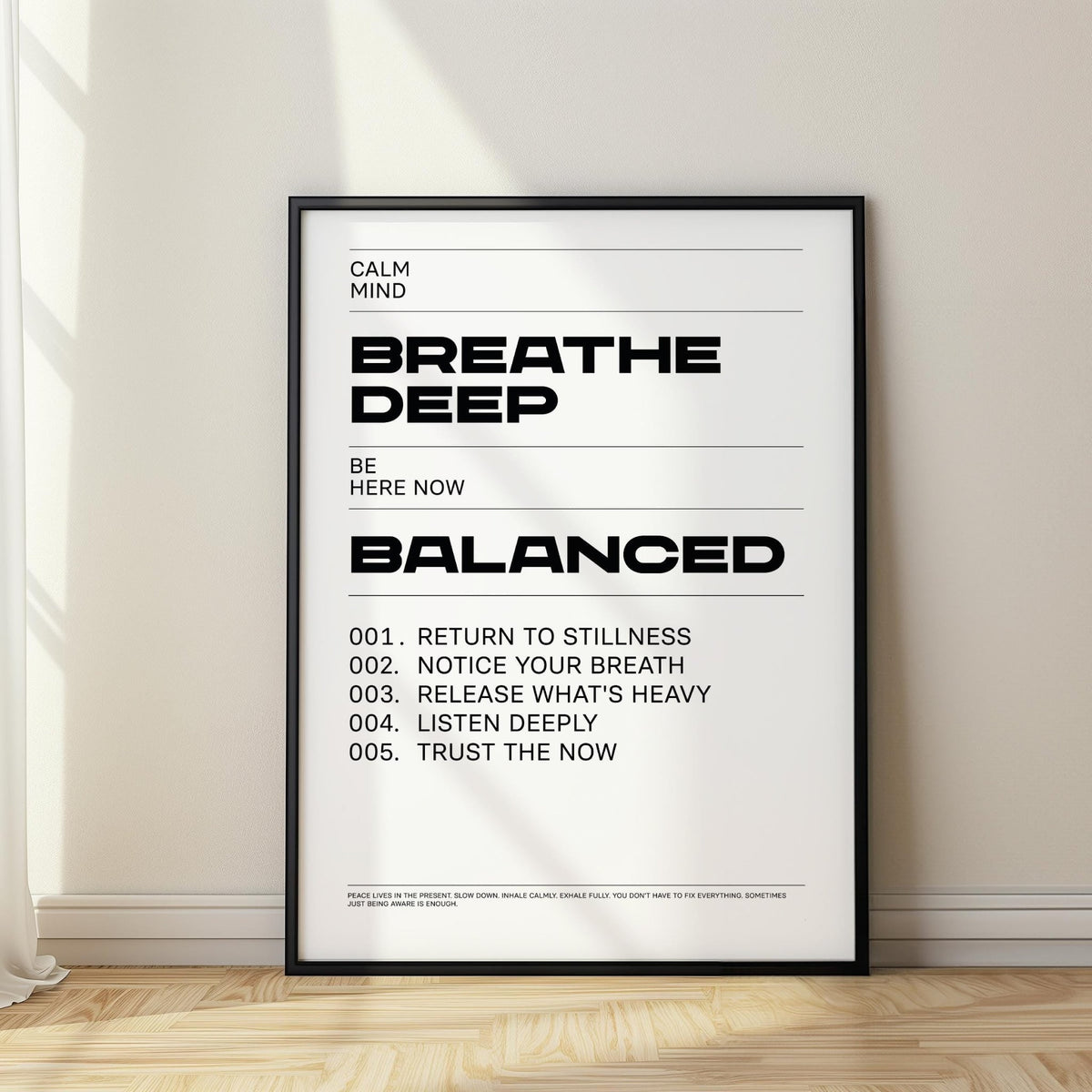 Print leaning on a floor with minimalist typographic motivational text in black and white