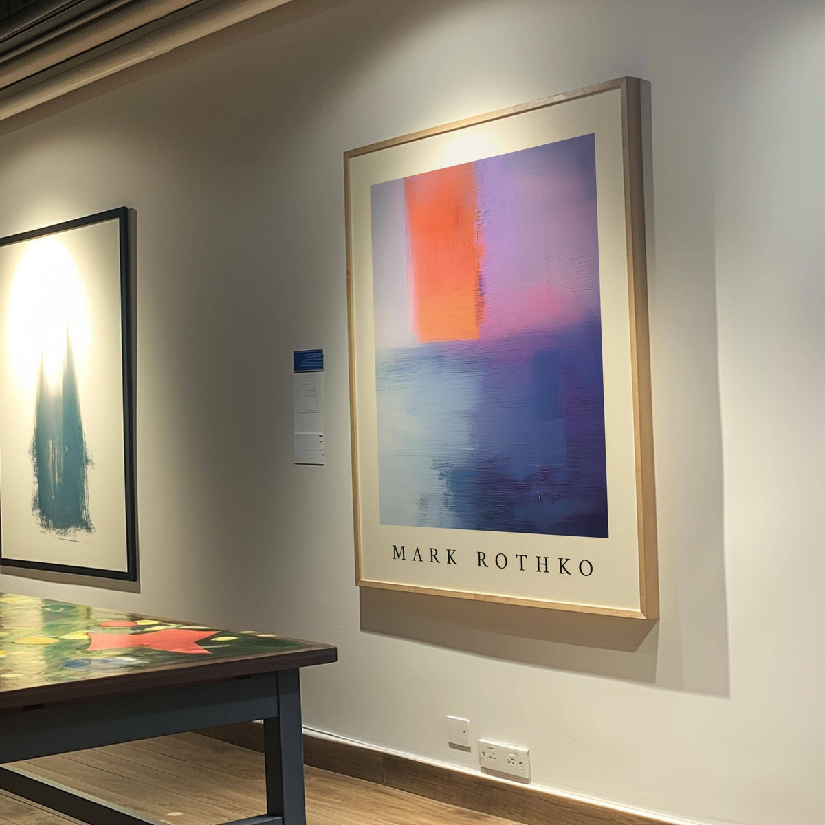 Rothko Art print of abstract blocks in orange and blue on a gallery wall above a table