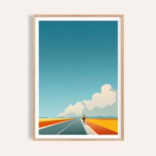 Framed print close-up of Bicycle Journey wall art showing cyclist on blue and orange road with blue sky