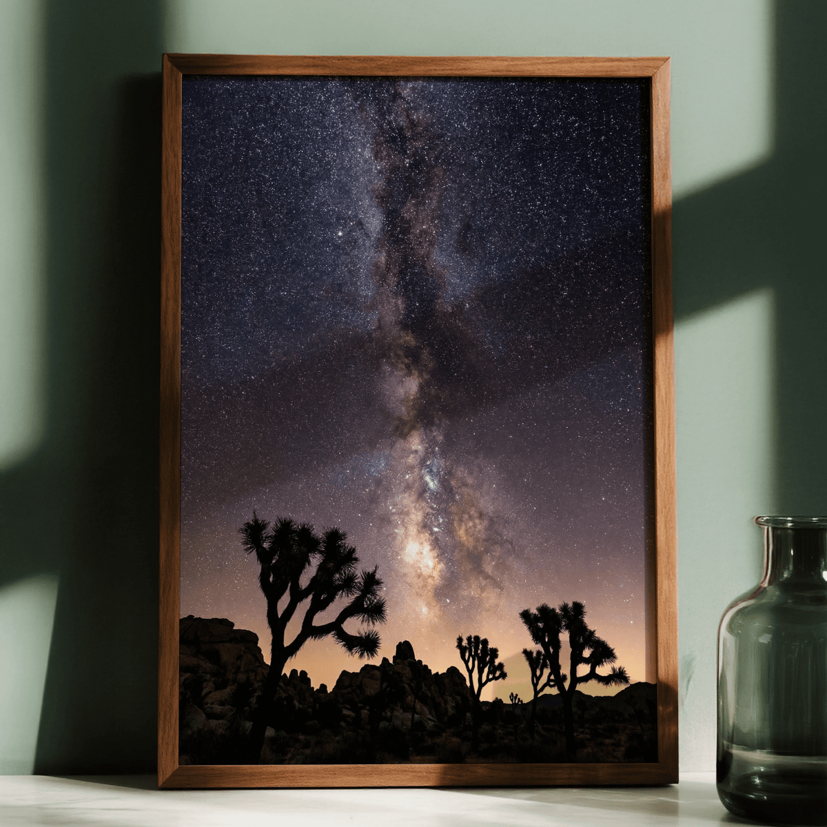 Framed Night Desert Poster with the milky way above silhouetted desert trees and rocks on a green wall with a glass vase nearby