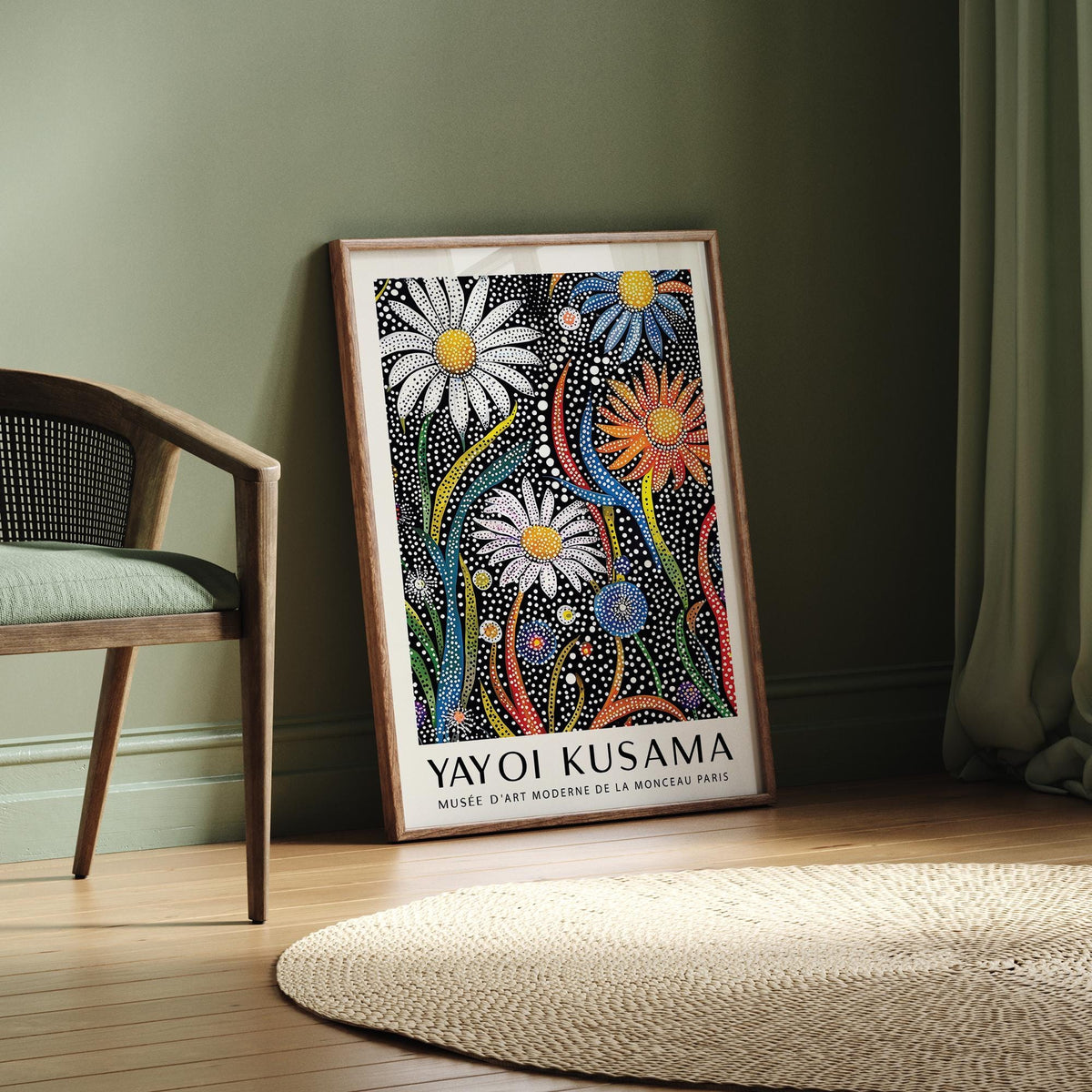Flower print for framing leaning on a wooden floor against a green wall near a chair in a room