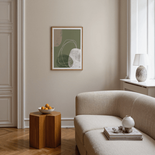 Modern Organic Print on a living room wall with green and beige abstract shapes above a wooden side table with a bowl