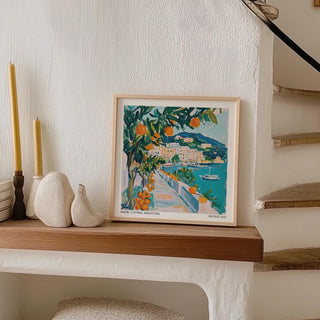 Art prints of Italy framed print of an orange tree by seaside path with teal and orange tones on a wooden mantle