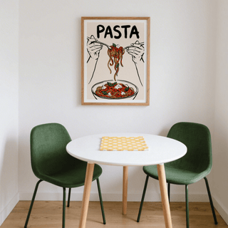 Pasta Art Print above a round white dining table with green chairs in a corner